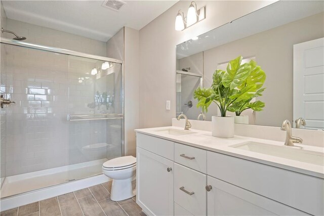8701 SW Edgewater Dr, Blue Springs, MO 64064 - bathroom featuring double vanity, a stall shower, and wood finish floors