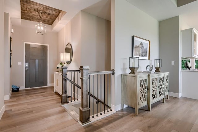 entryway featuring an inviting chandelier, wooden ceiling, and light wood-type flooring