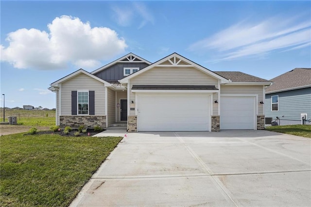 craftsman inspired home with stone siding, an attached garage, concrete driveway, and a front yard