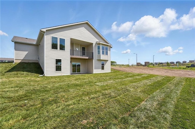 back of property with a balcony and a yard