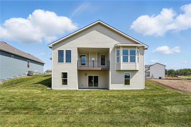 back of house with a lawn, a balcony, and central air condition unit