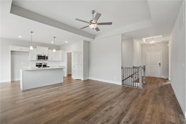 unfurnished living room with baseboards, wood finished floors, a ceiling fan, and recessed lighting