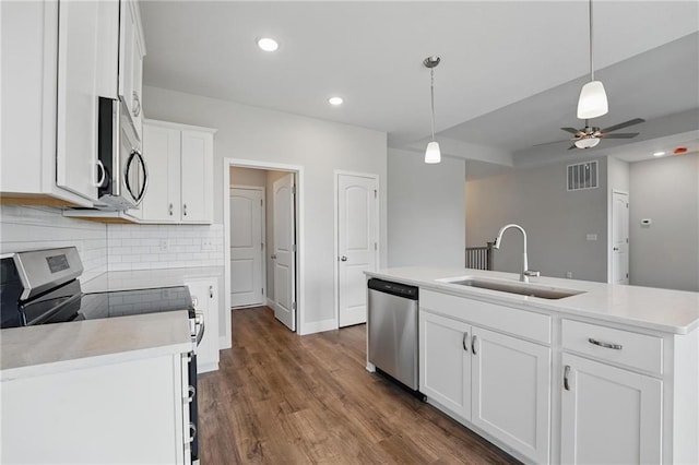 kitchen featuring stainless steel appliances, a sink, backsplash, white cabinetry, and light countertops