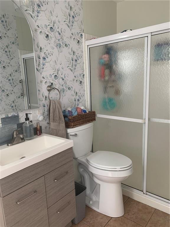 bathroom with vanity, toilet, walk in shower, and tile patterned floors