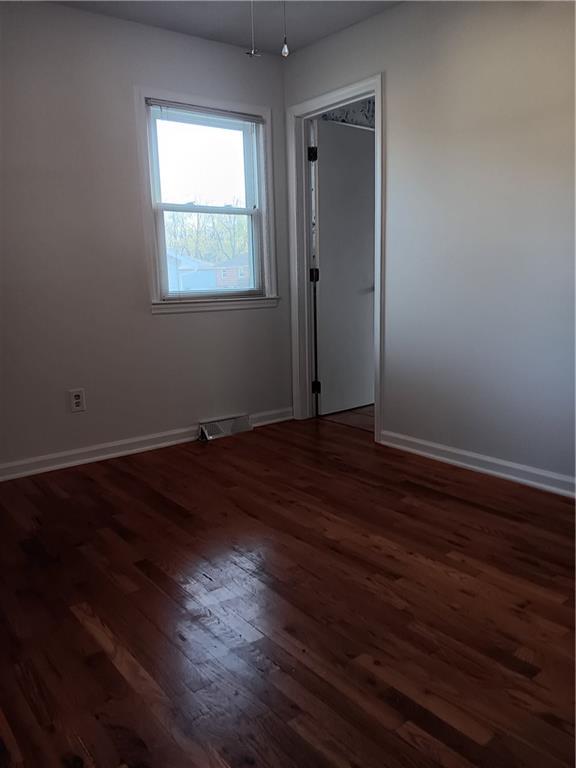 305 18th Ave N, Greenwood, MO 63034 - spare room with baseboards, dark wood finished floors, and visible vents