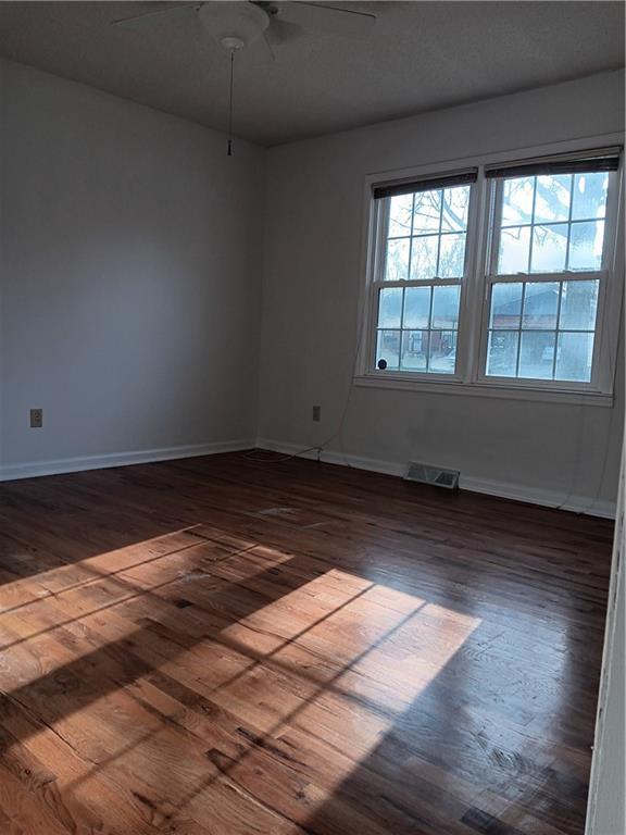 305 18th Ave N, Greenwood, MO 63034 - spare room featuring ceiling fan, baseboards, dark wood-style floors, and visible vents