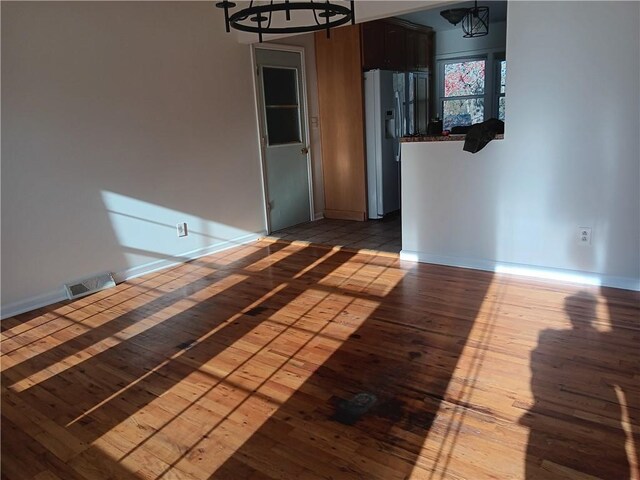 305 18th Ave N, Greenwood, MO 63034 - empty room featuring baseboards, an inviting chandelier, wood-type flooring, and visible vents