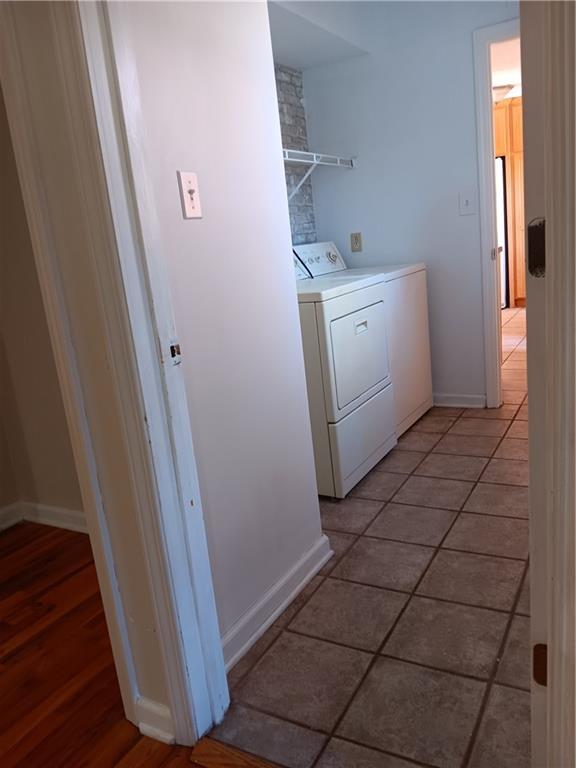 305 18th Ave N, Greenwood, MO 63034 - laundry area with baseboards, light tile patterned floors, laundry area, and washing machine and clothes dryer