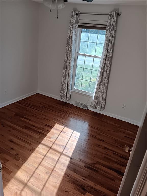 305 18th Ave N, Greenwood, MO 63034 - unfurnished room featuring visible vents, baseboards, a ceiling fan, and wood finished floors