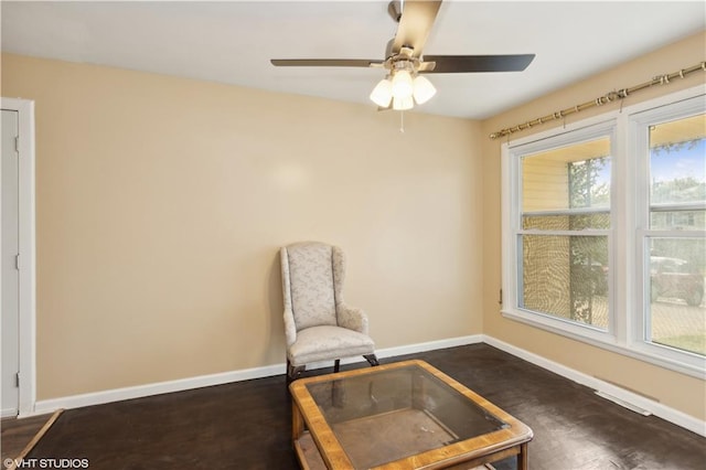 living area featuring ceiling fan, a healthy amount of sunlight, and dark hardwood / wood-style flooring