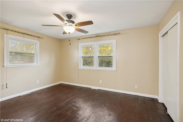 unfurnished bedroom with ceiling fan, dark hardwood / wood-style floors, and a closet