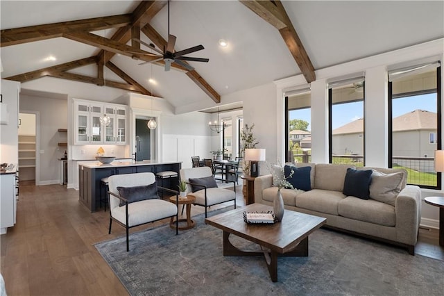 living room with beam ceiling, high vaulted ceiling, ceiling fan with notable chandelier, and dark hardwood / wood-style flooring