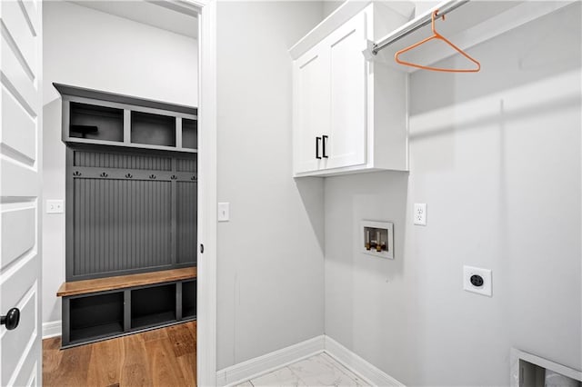 clothes washing area featuring cabinets, hookup for a washing machine, light wood-type flooring, and electric dryer hookup