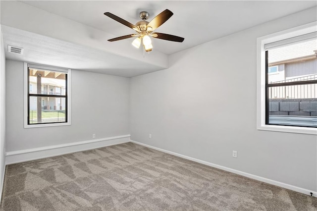 spare room featuring light colored carpet and ceiling fan