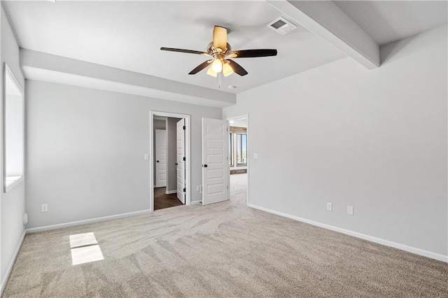 unfurnished room with beamed ceiling, carpet, and ceiling fan