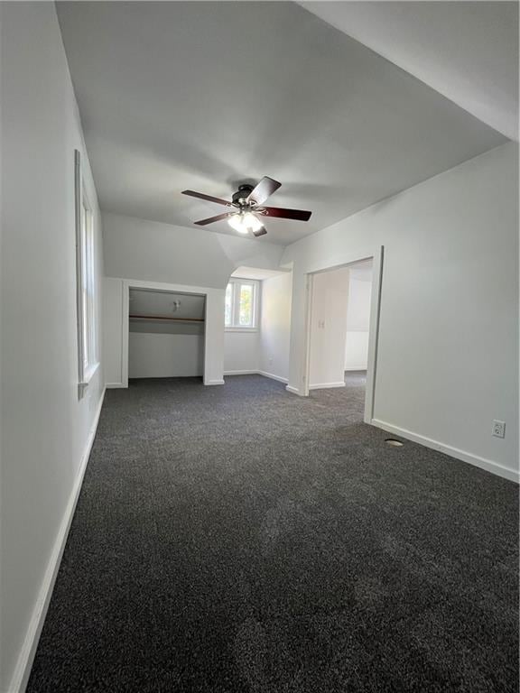 unfurnished room with dark carpet and ceiling fan