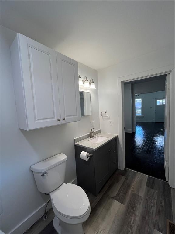 bathroom featuring vanity, toilet, and hardwood / wood-style flooring