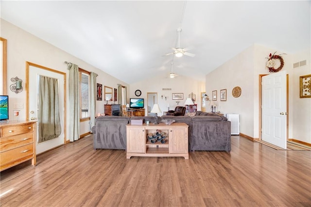 living room with lofted ceiling, hardwood / wood-style floors, and ceiling fan