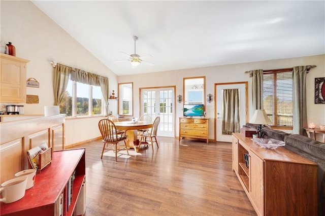 dining area with ceiling fan, wood-type flooring, and vaulted ceiling