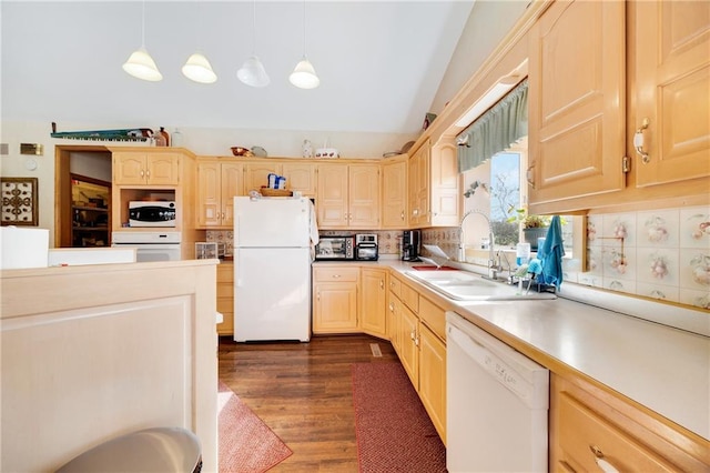 kitchen with light brown cabinetry, lofted ceiling, sink, hanging light fixtures, and white appliances