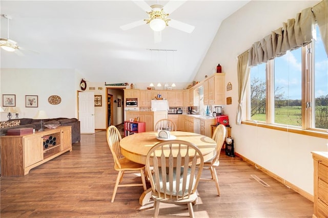 dining area featuring rail lighting, lofted ceiling, ceiling fan, and light hardwood / wood-style flooring