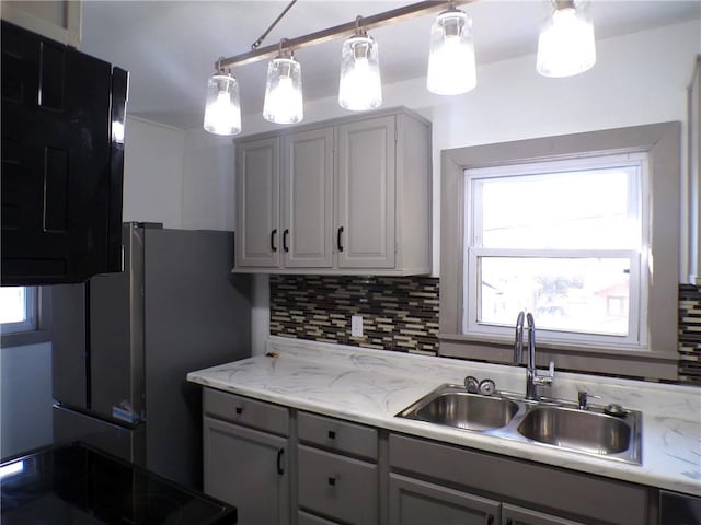 kitchen featuring a wealth of natural light, tasteful backsplash, and gray cabinets