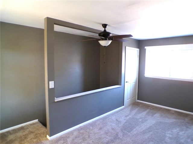 carpeted spare room featuring ceiling fan