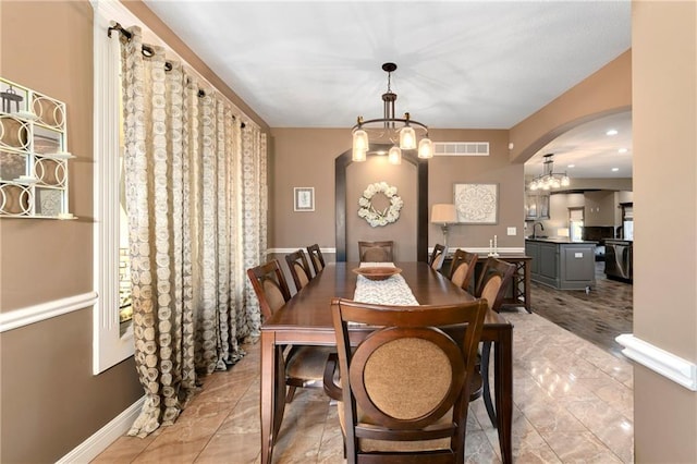 dining area featuring sink and an inviting chandelier