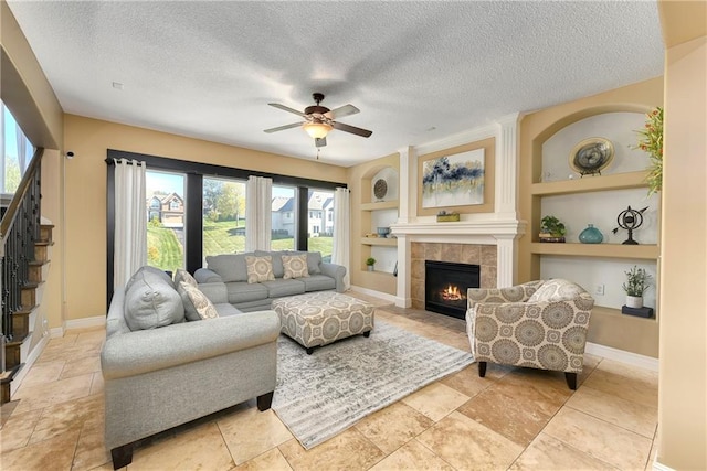 living room featuring built in features, a textured ceiling, and plenty of natural light