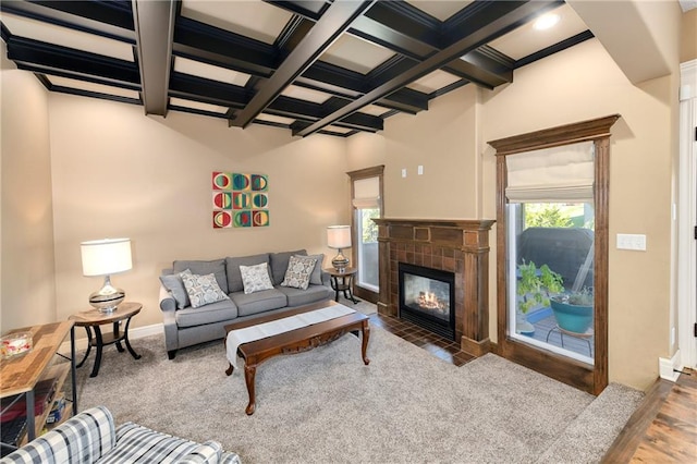 living room with beamed ceiling, hardwood / wood-style floors, coffered ceiling, and a tile fireplace