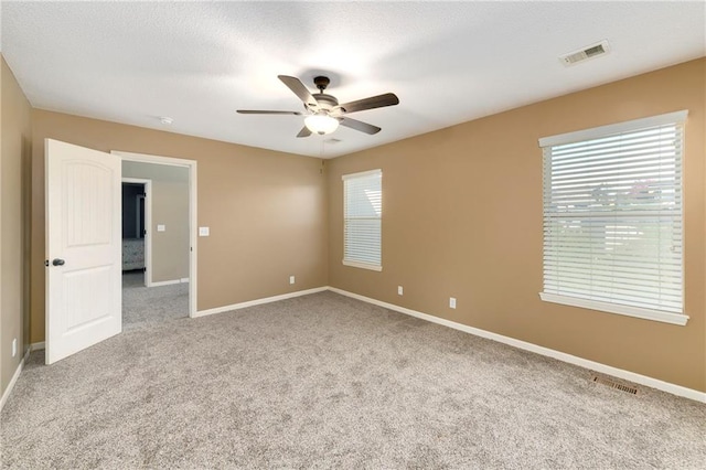 carpeted spare room with ceiling fan