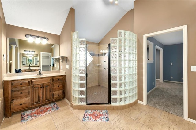 bathroom featuring vanity, decorative columns, a tile shower, and lofted ceiling