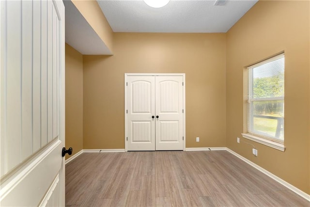 empty room featuring a textured ceiling and light hardwood / wood-style floors