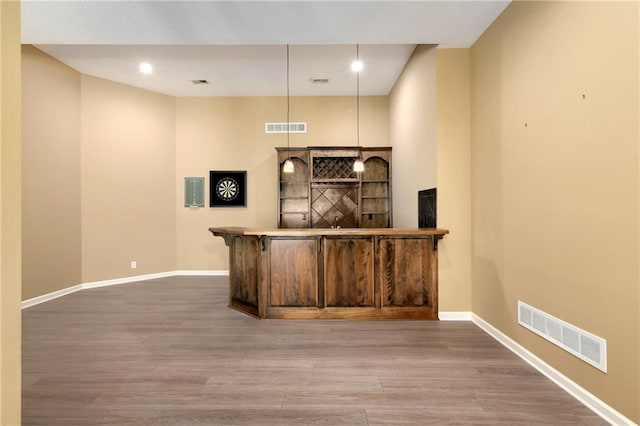 bar featuring hardwood / wood-style floors and hanging light fixtures