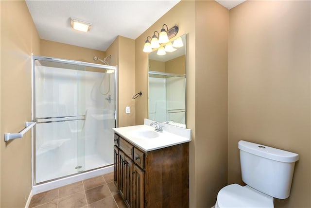 bathroom with vanity, tile patterned flooring, toilet, and a shower with door