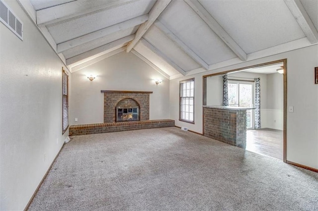 unfurnished living room with vaulted ceiling with beams, carpet, and a brick fireplace