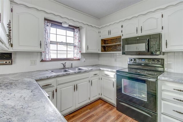 kitchen with white cabinetry, black appliances, light hardwood / wood-style floors, crown molding, and sink