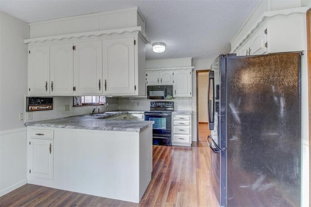 kitchen with decorative backsplash, dark hardwood / wood-style floors, sink, black appliances, and white cabinetry