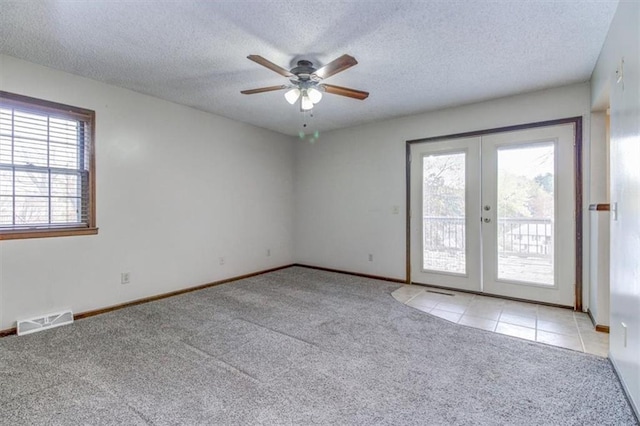 spare room with light carpet, french doors, a textured ceiling, and ceiling fan