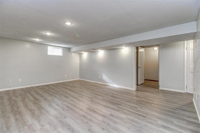 basement with light hardwood / wood-style flooring and a textured ceiling