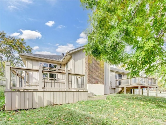 back of property with a wooden deck and a yard