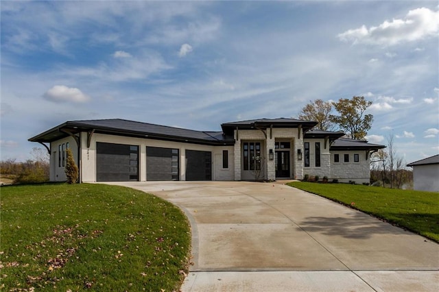 prairie-style home with a garage and a front lawn