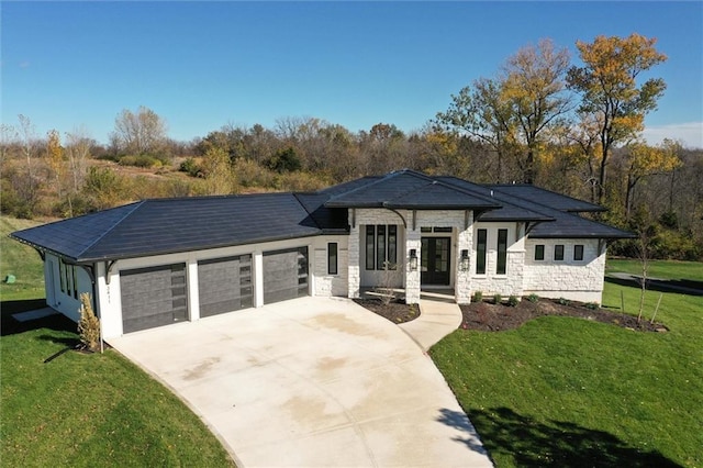 prairie-style home featuring a garage and a front lawn