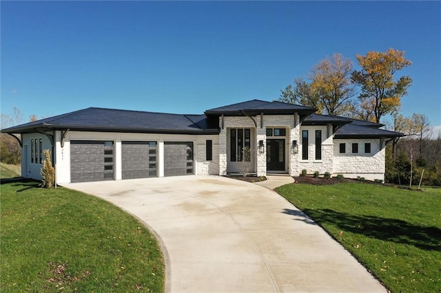 prairie-style house featuring a garage and a front yard