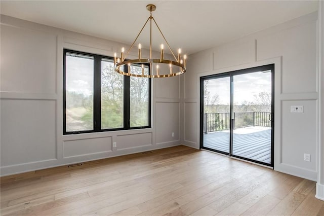 3411 S Mize Ridge Ct, Independence, MO 64057 - spare room featuring a decorative wall, a chandelier, and light wood-type flooring