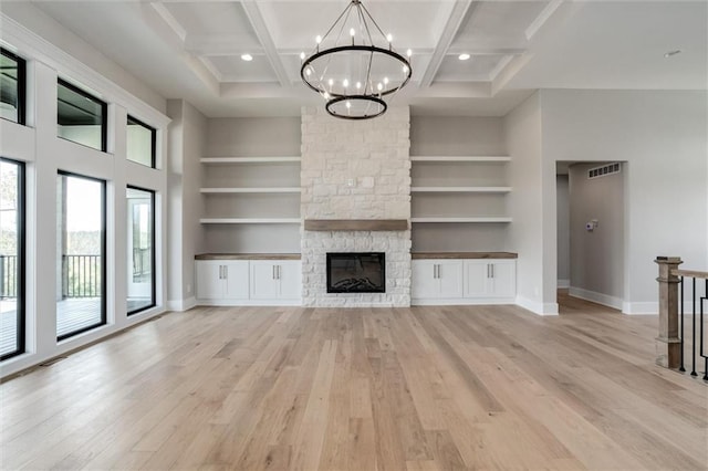 unfurnished living room with built in shelves, beam ceiling, coffered ceiling, and light hardwood / wood-style flooring