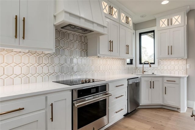 3411 S Mize Ridge Ct, Independence, MO 64057 - kitchen featuring appliances with stainless steel finishes, custom exhaust hood, a sink, light countertops, and light wood-style floors