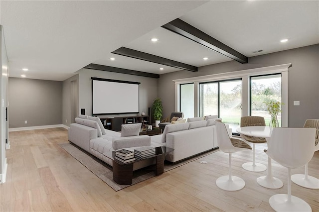 home theater room featuring light hardwood / wood-style floors and beamed ceiling