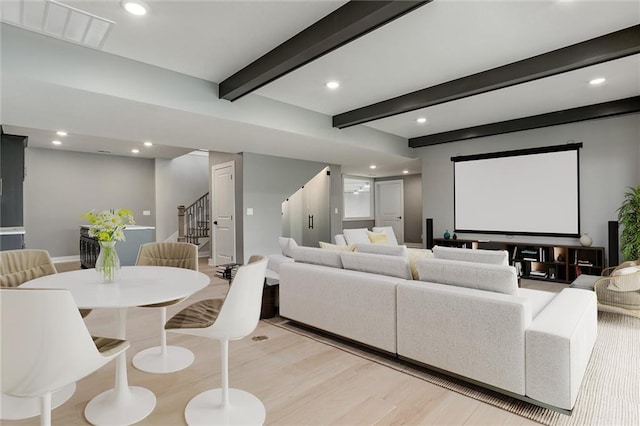 cinema room featuring light hardwood / wood-style floors and beamed ceiling