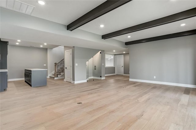 unfurnished living room featuring light hardwood / wood-style floors and beam ceiling